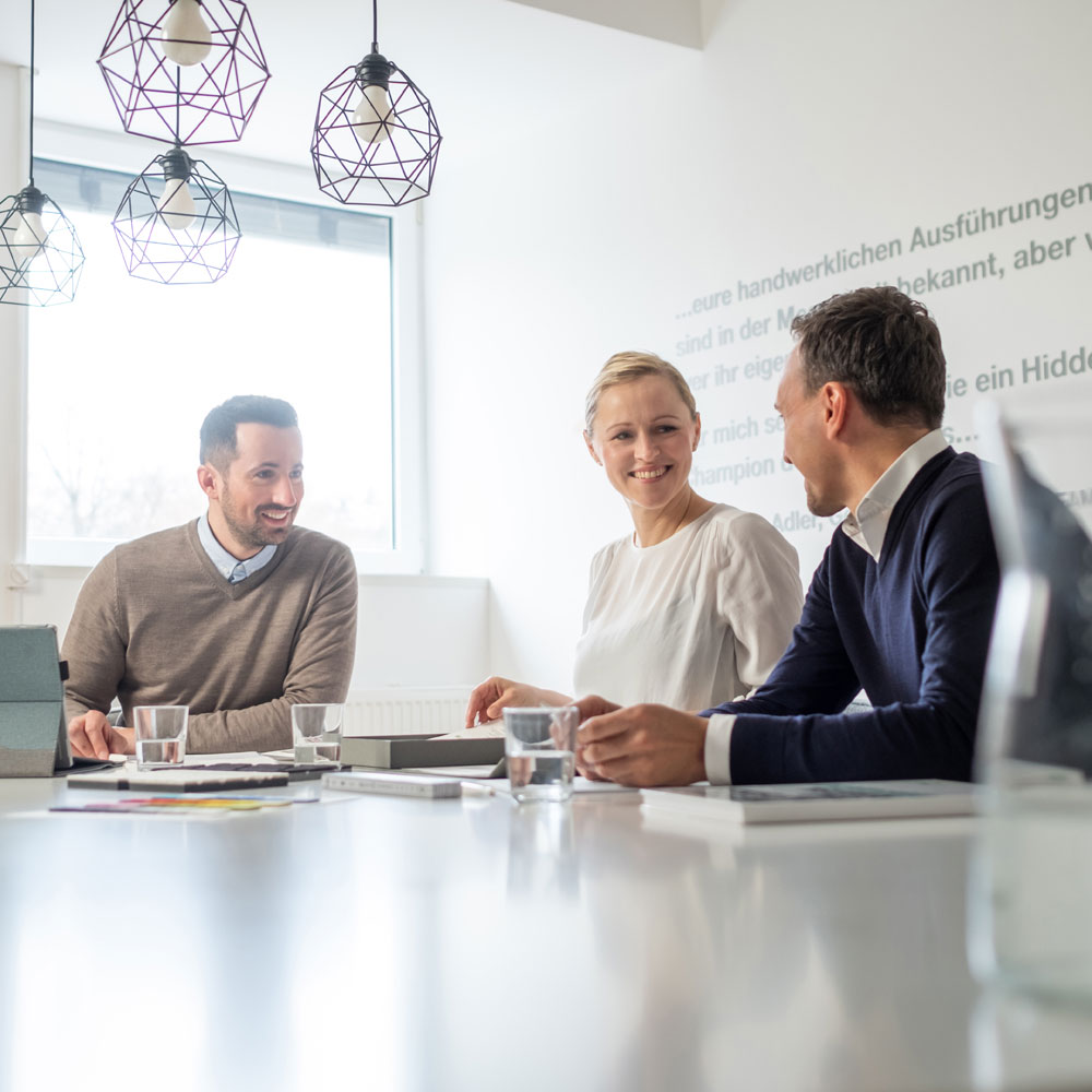 tuennissen-leistungen-beratung Chef, Designer und Vertriebler im konstruktiven Austausch am Besprechungstisch - Tünnissen Interiors, Messen, Events und Ausstellungen NRW Deutschland Europe