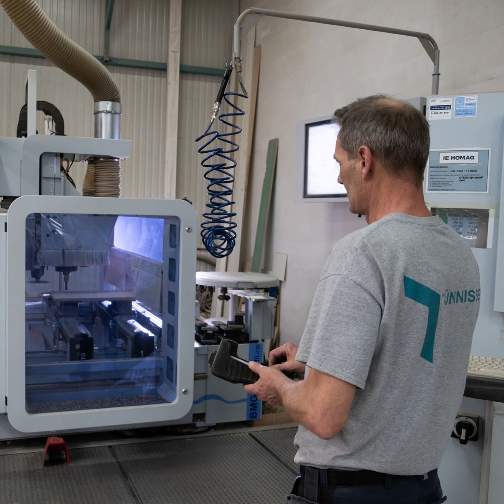 tuennissen-leistungen-produktion Mitarbeiter steuert die CNC-Fräse in der Produktion - Tünnissen Interiors, Messen, Events und Ausstellungen NRW Deutschland Europe