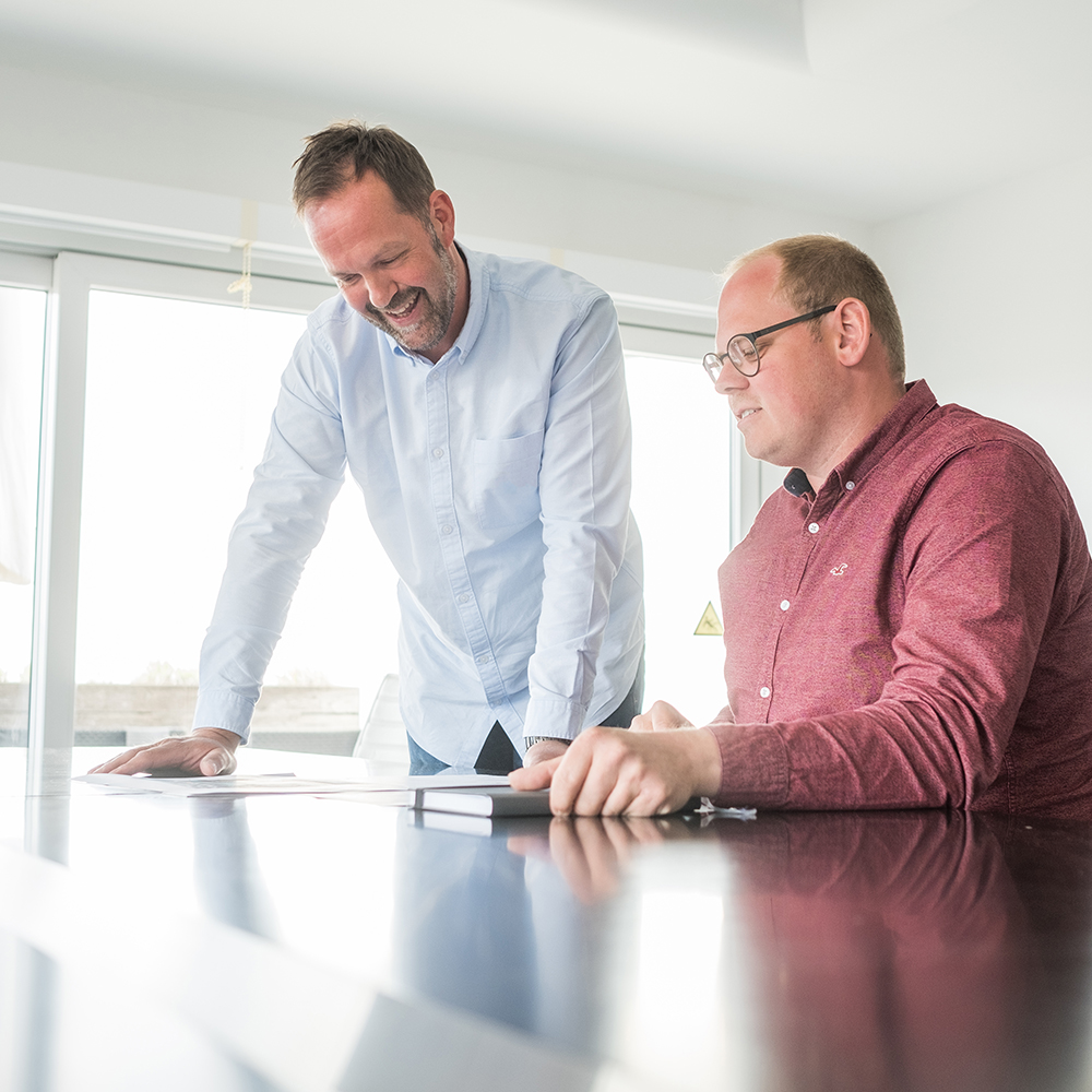 tuennissen-karriere-projekt Drei Projektleiter im Gespräch über einer Konstruktionszeichnung - - Tünnissen Interiors, Messen, Events und Ausstellungen NRW Deutschland Europe